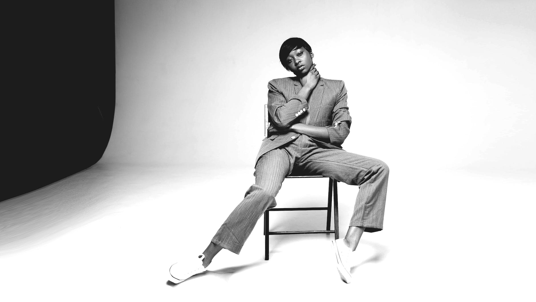 grayscale photo of person sitting on chair